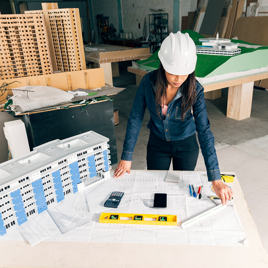 Professional architect working with blueprints and architectural models
